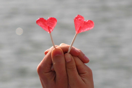 La Oxitocina hormona del amor y su impacto en la fertilidad y en la salud reproductiva foto de pareja tomada de la mano con dulces en forma de corazón Dew Navarrete